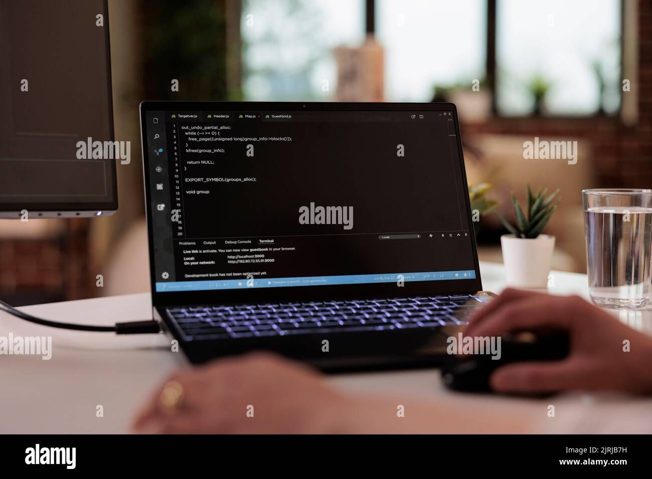 developer working on laptop with localhost web application running in terminal